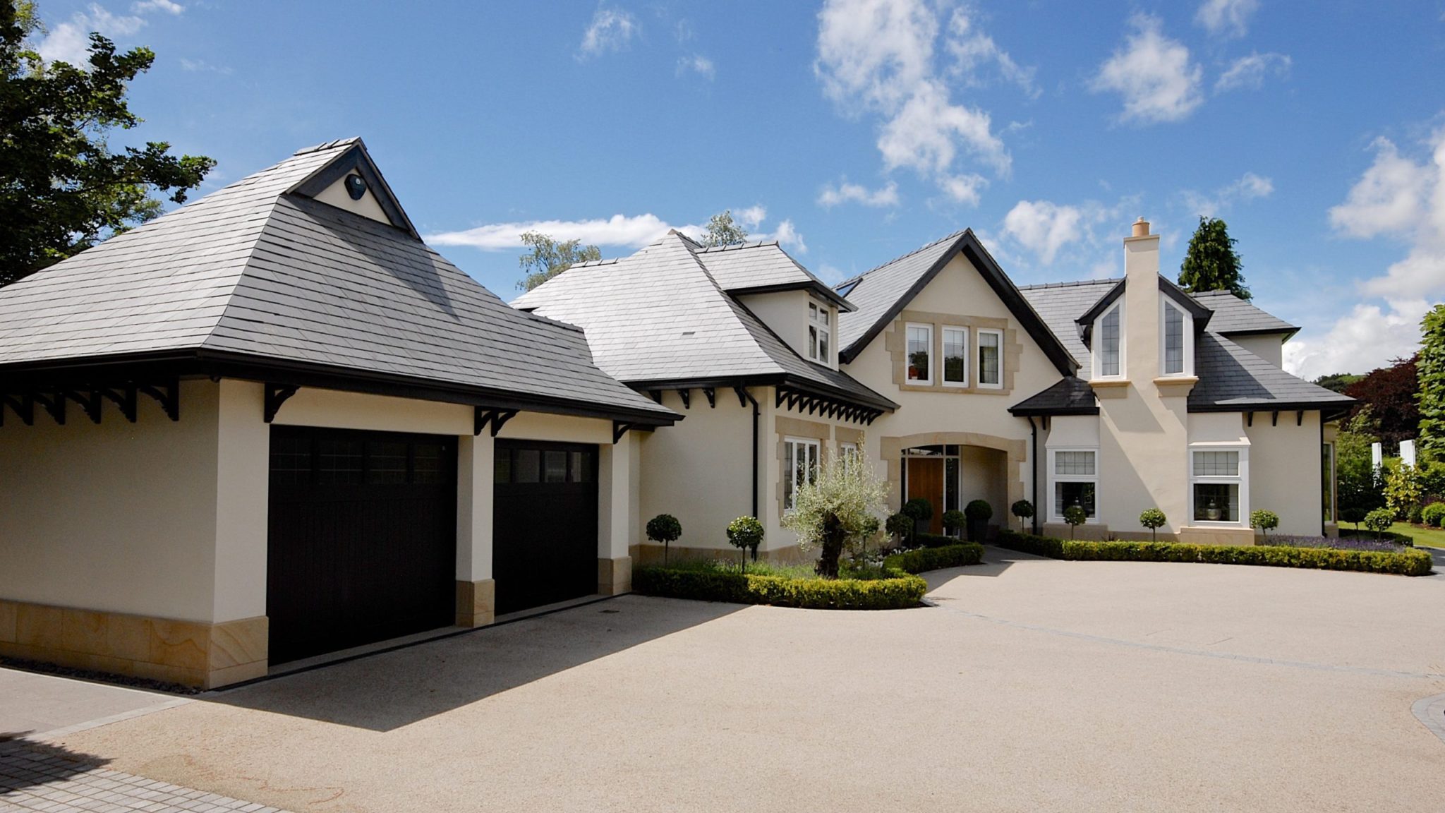 a large white house with a black garage.