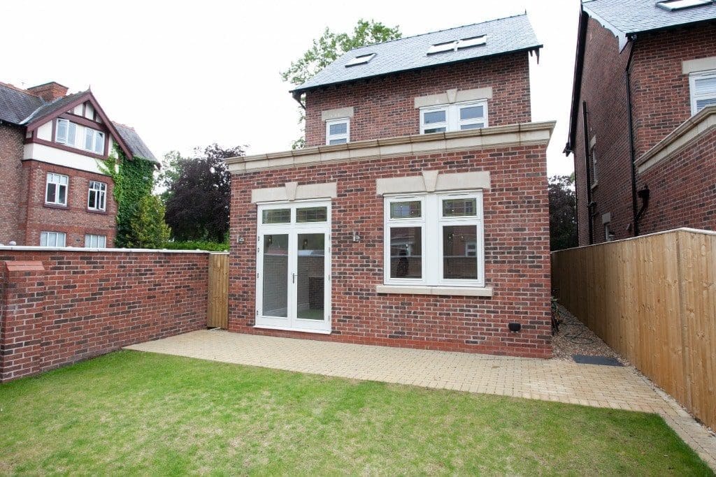 a brick house with a fence around it.