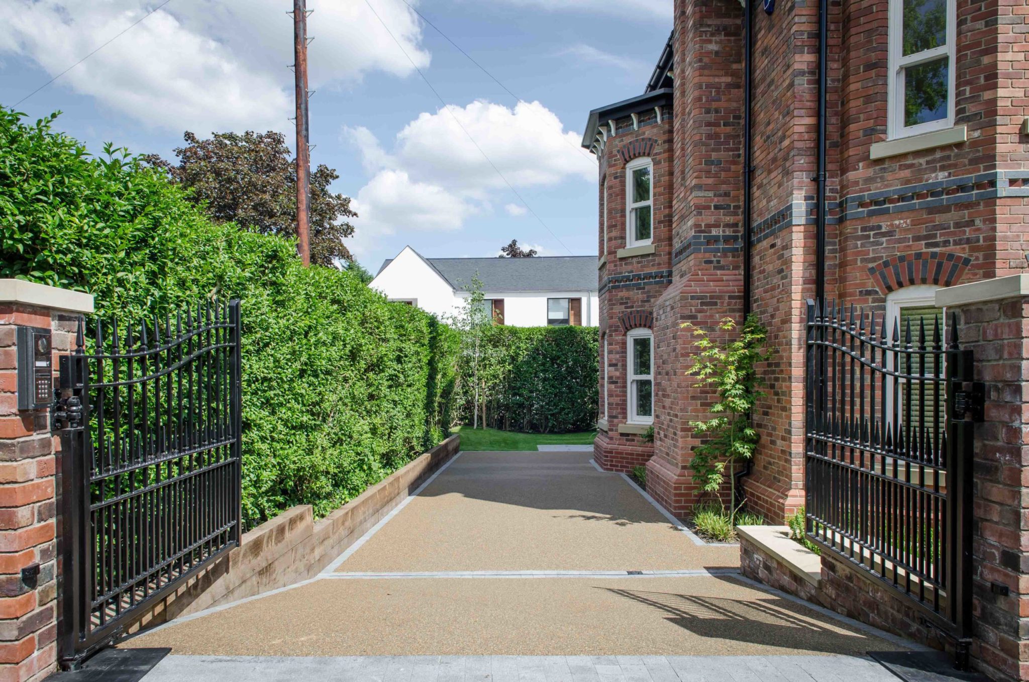 a gated driveway leading to a brick building.