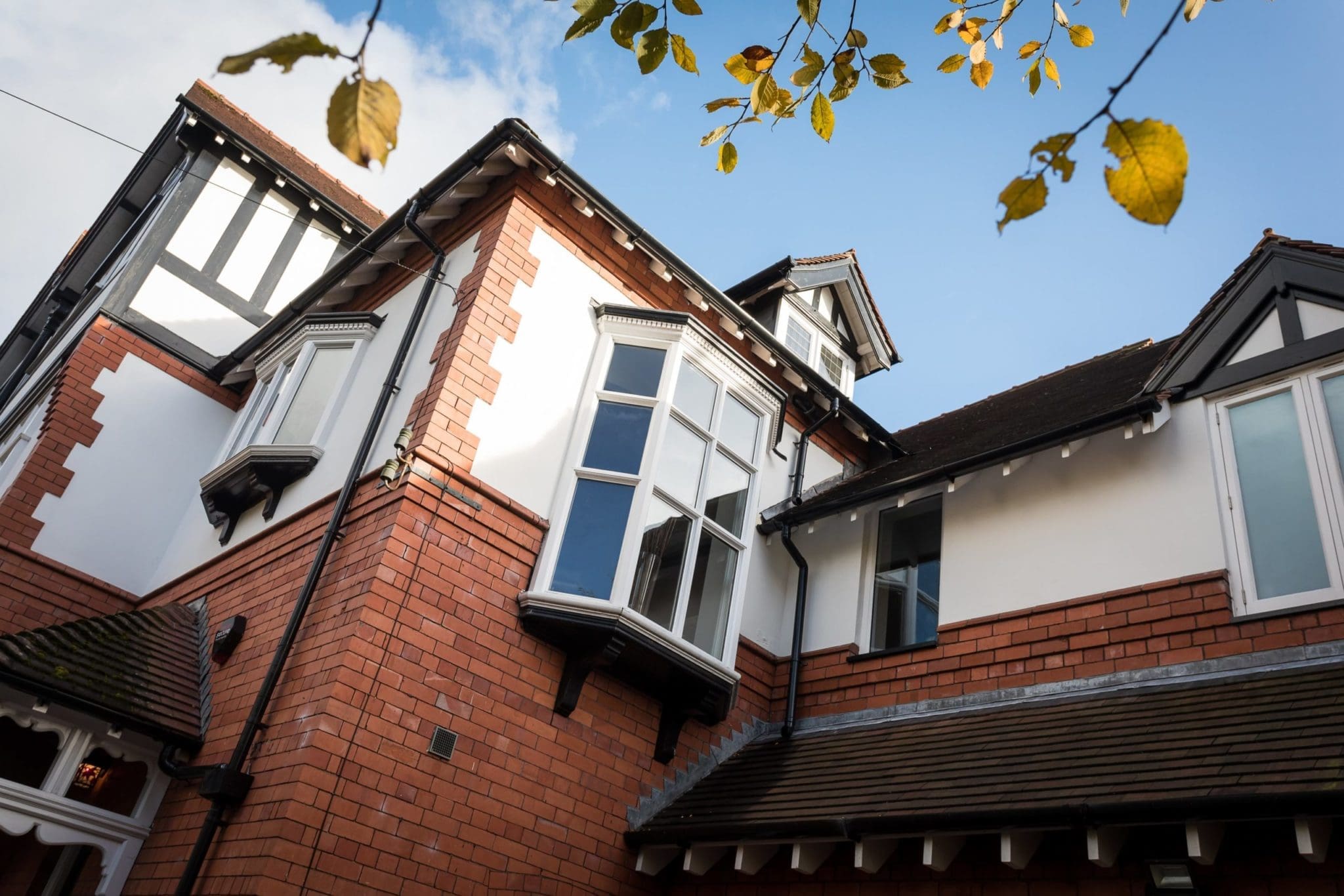 a red brick house with white windows and a brown roof.
