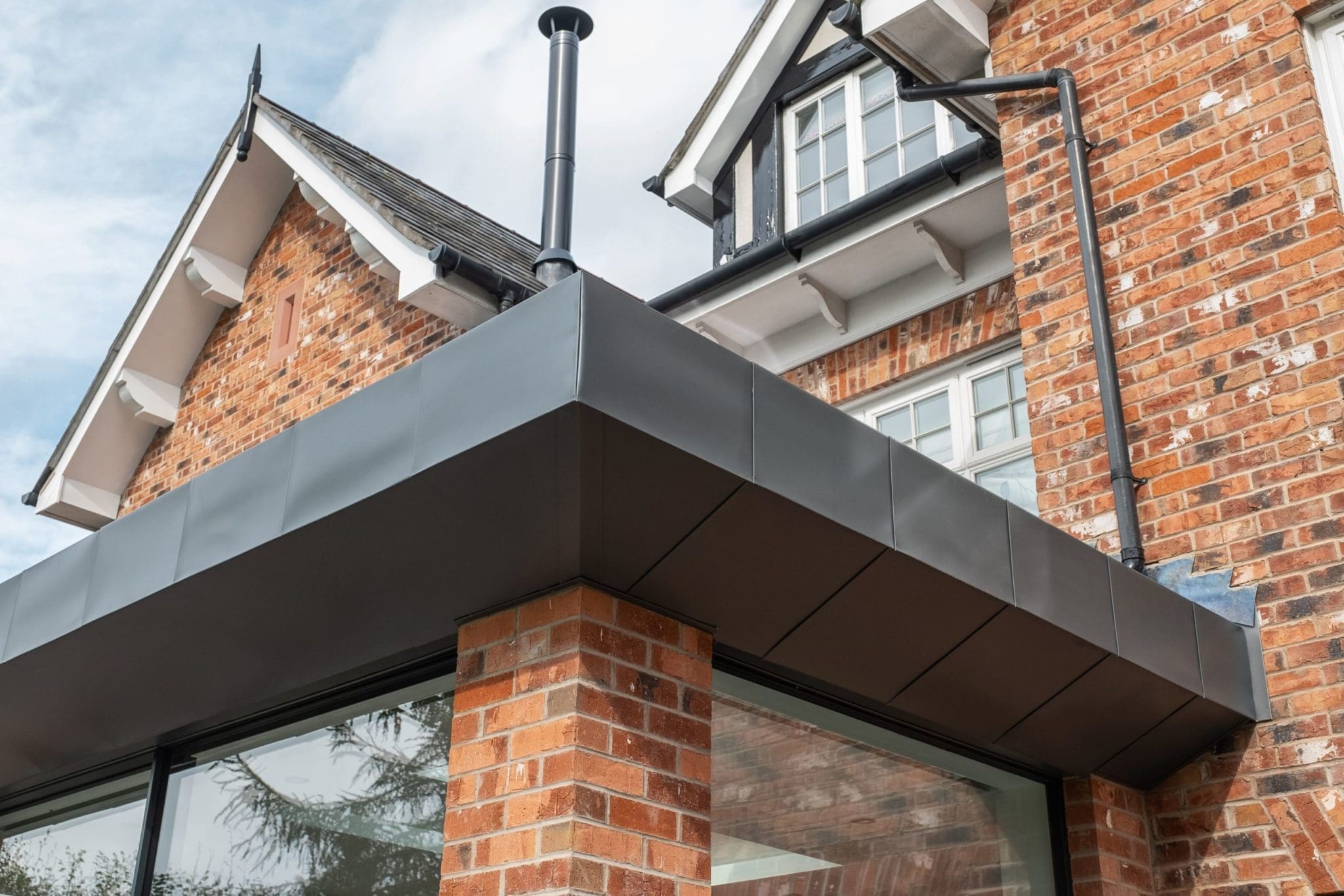 a close up of a brick building with a metal roof.