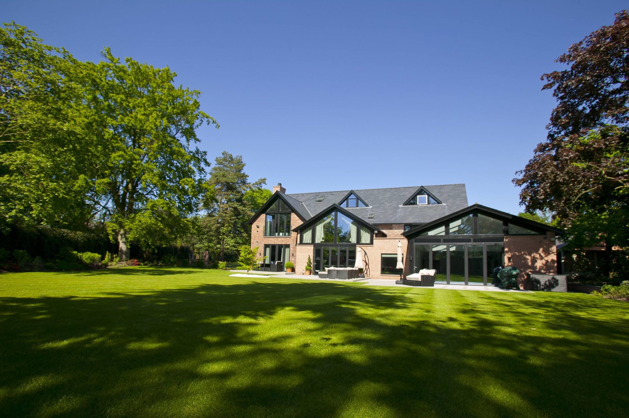 a large house sitting on top of a lush green field.