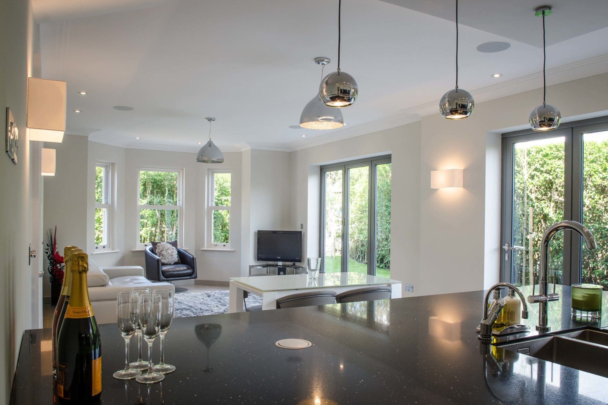 a kitchen with a black counter top next to a living room.