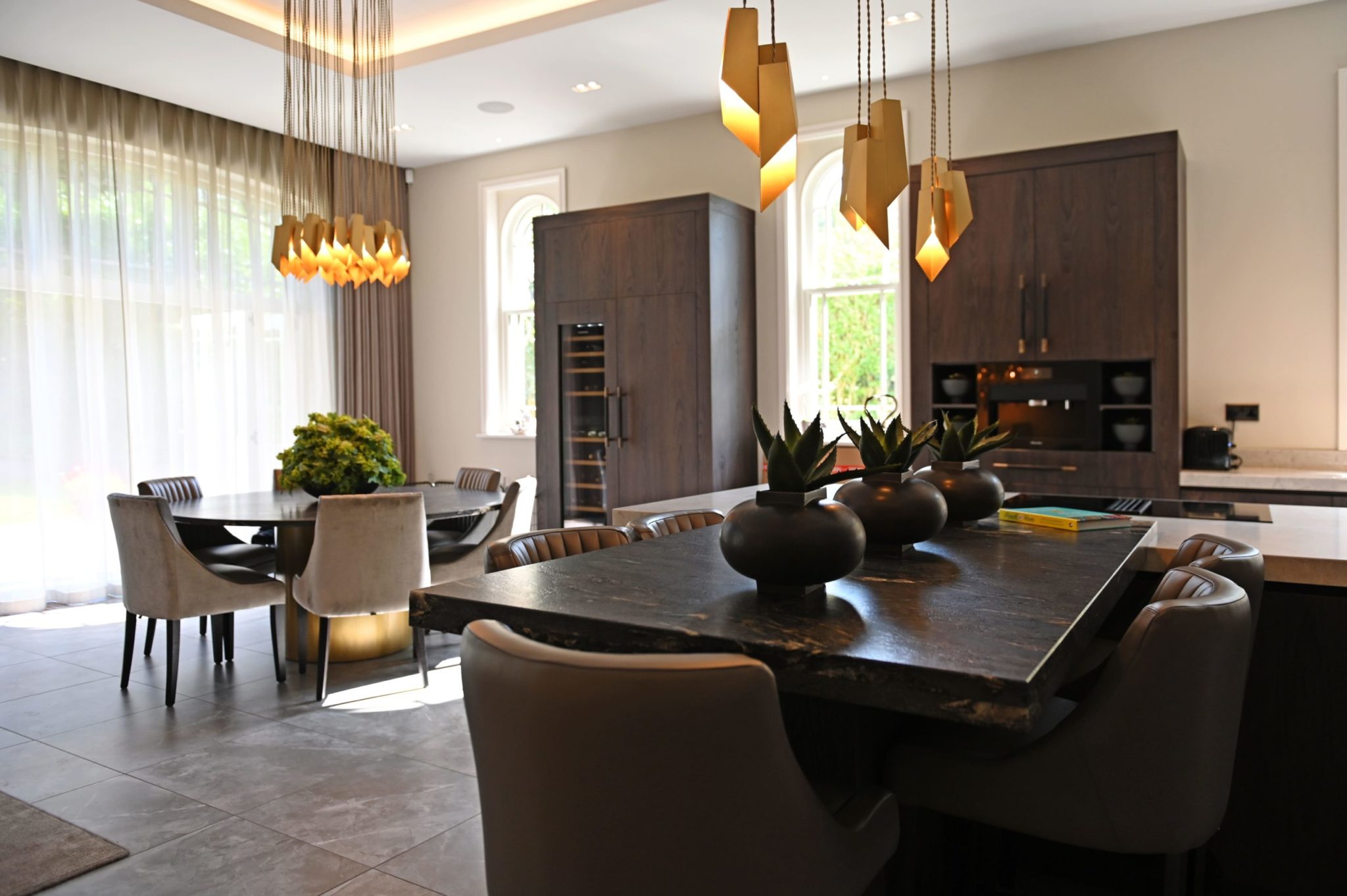 a kitchen with a table, chairs, cabinets and lights.