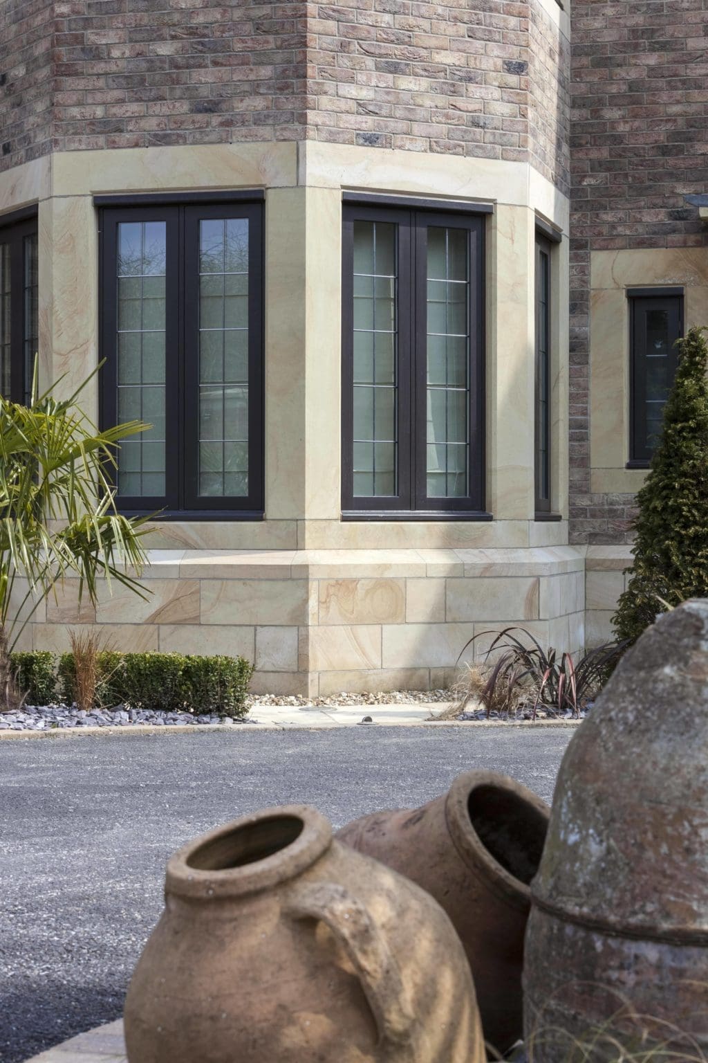 a couple of vases sitting in front of a brick house.