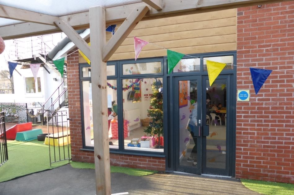 a building with a bunch of colored flag hanging from it's windows.