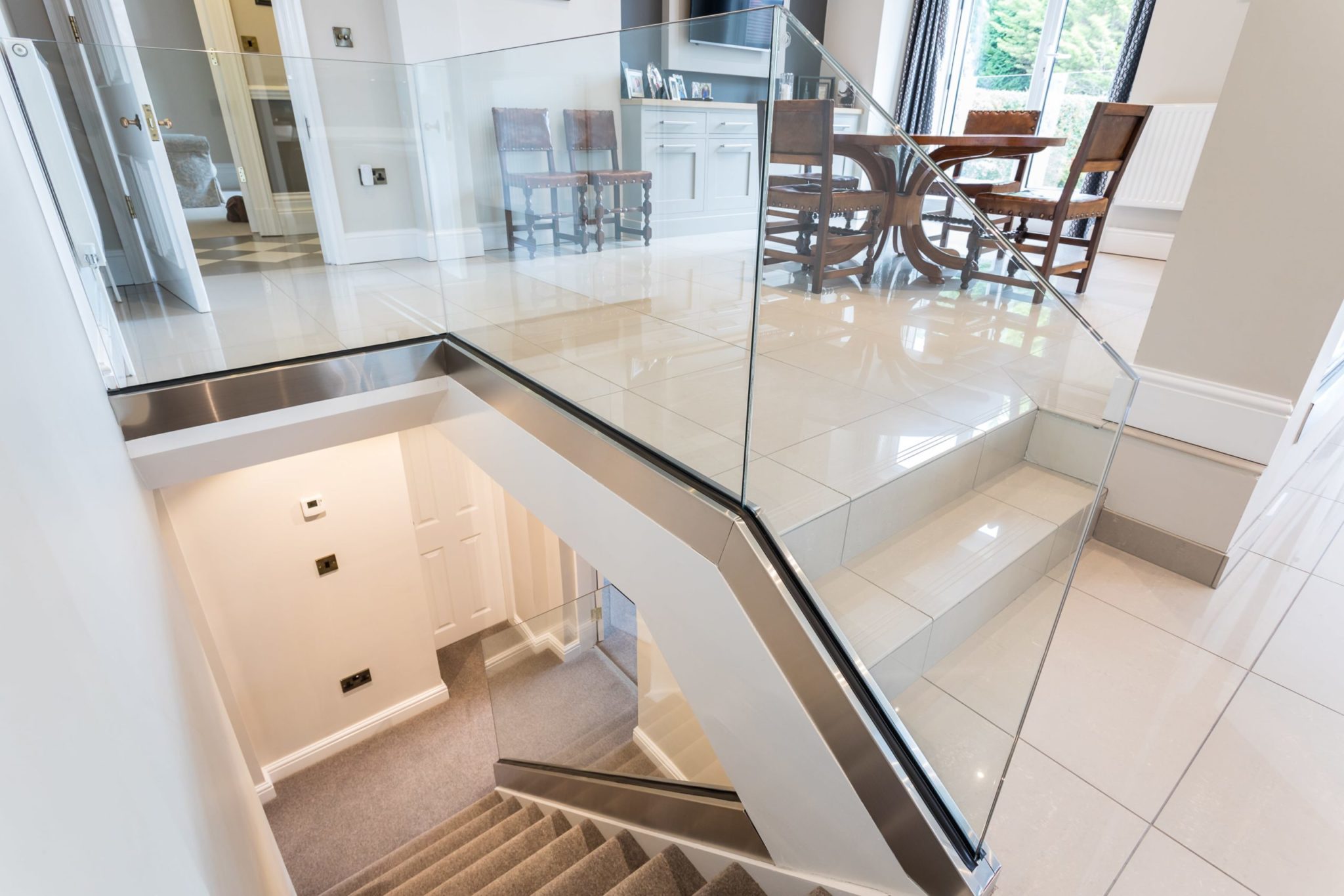 a staircase with a glass railing and a metal handrail.