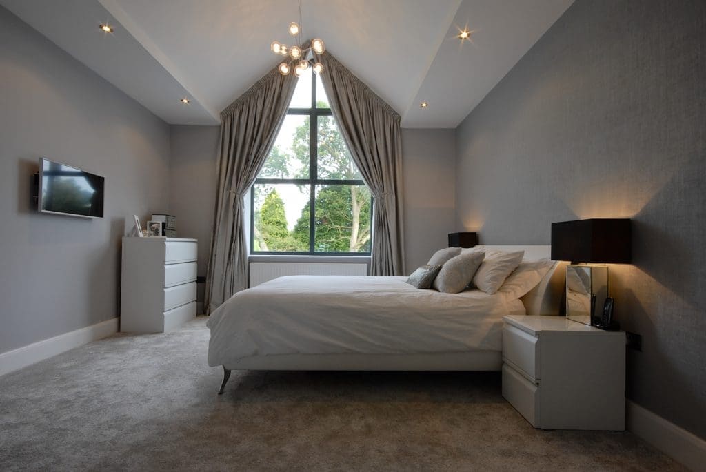 a bedroom with a large bed and a large window.