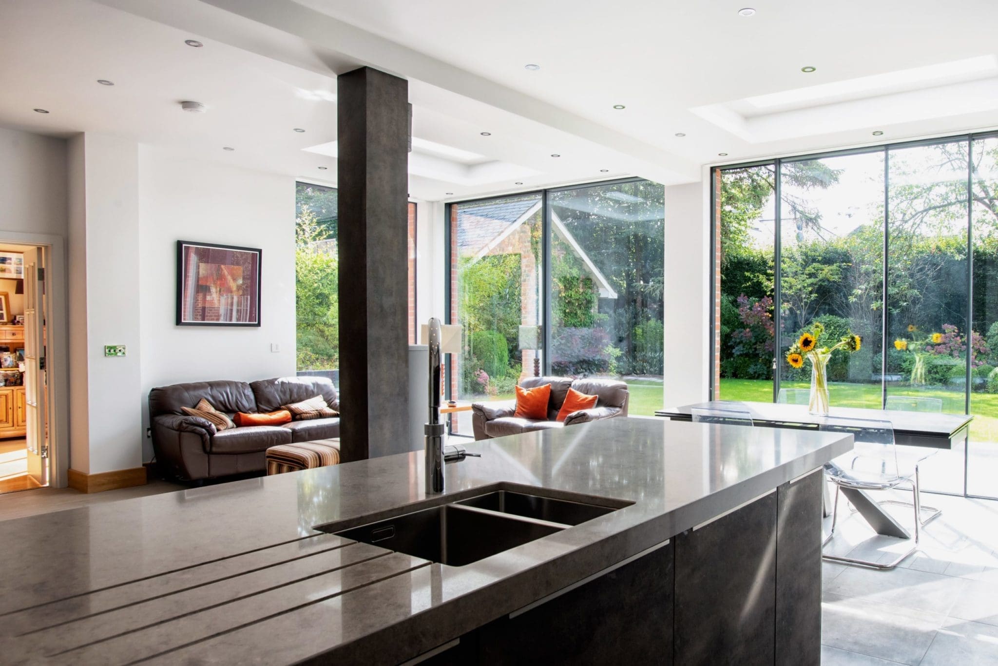 a kitchen and living room with large windows.