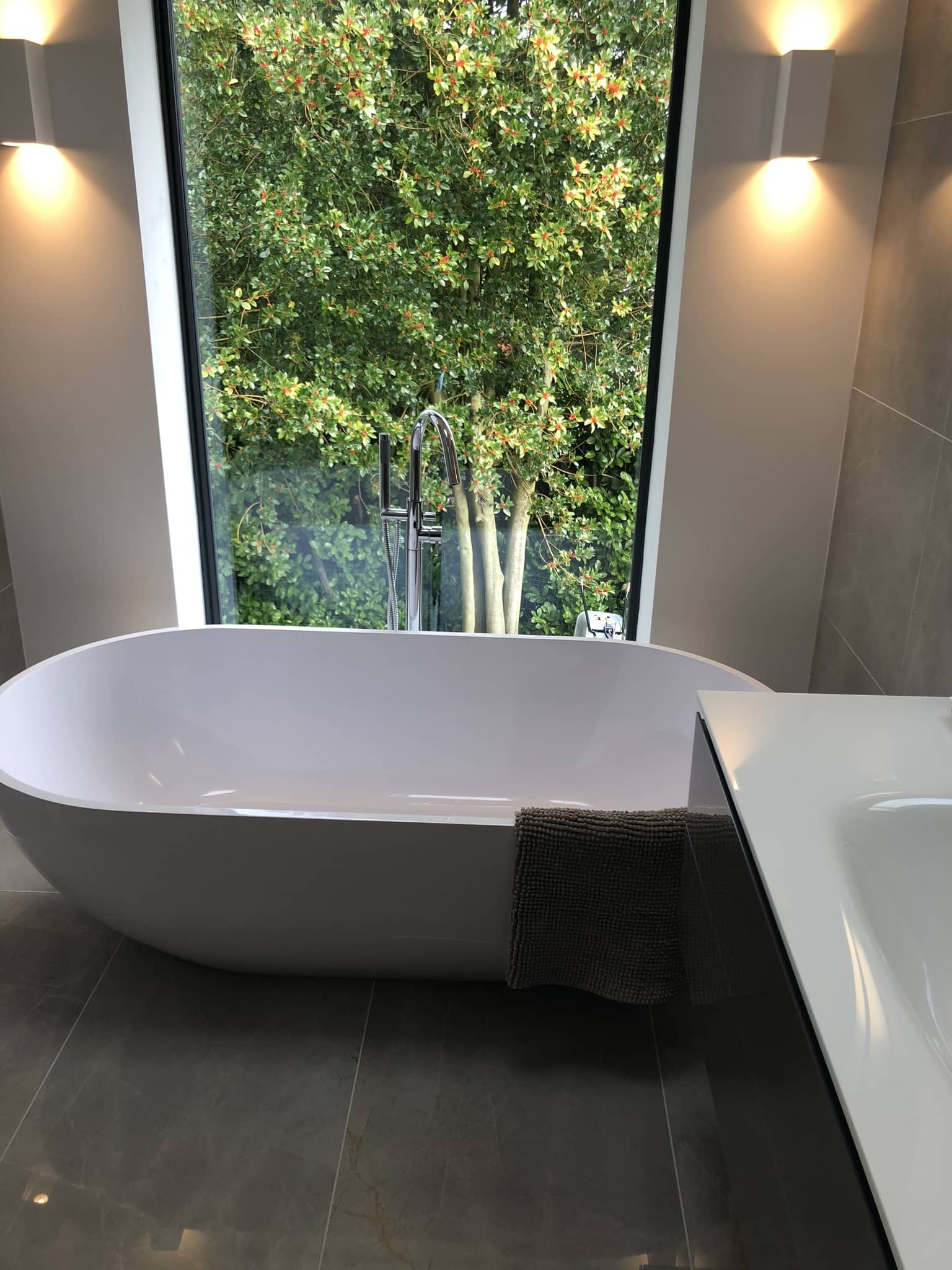 a white bath tub sitting in a bathroom next to a window.