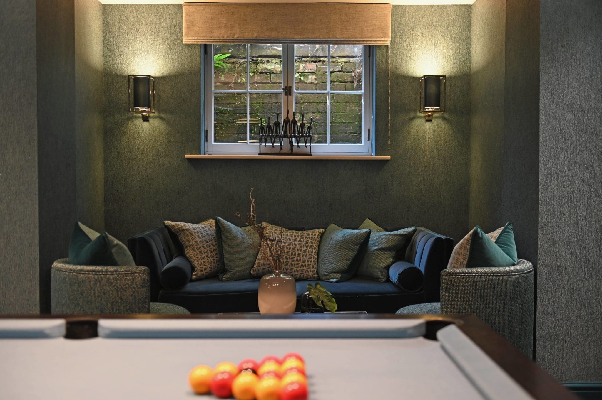 a pool table in a living room next to a couch.