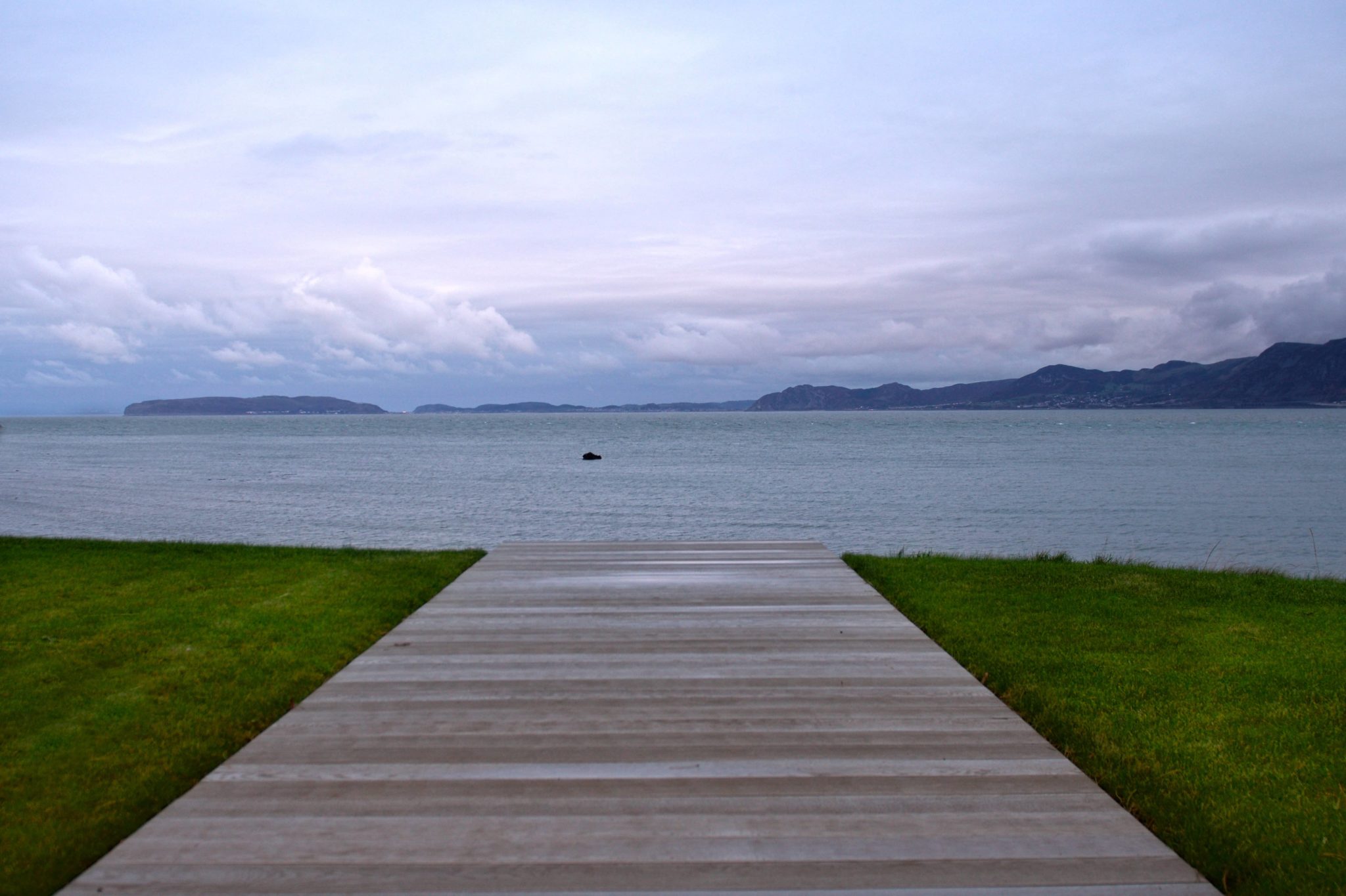 a wooden walkway leading to a body of water.