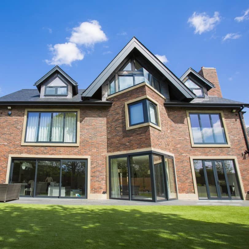 a large brick house with a large lawn.