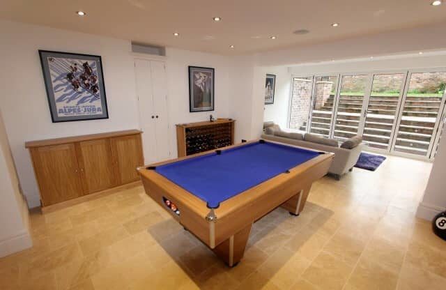 a living room with a pool table and a couch.