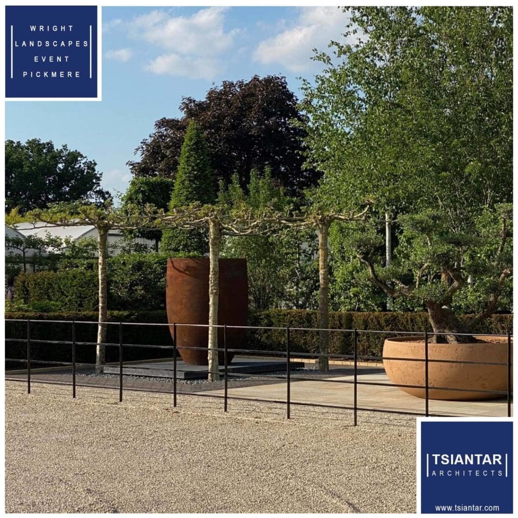 an image of a garden with a blue fence and a large planter.