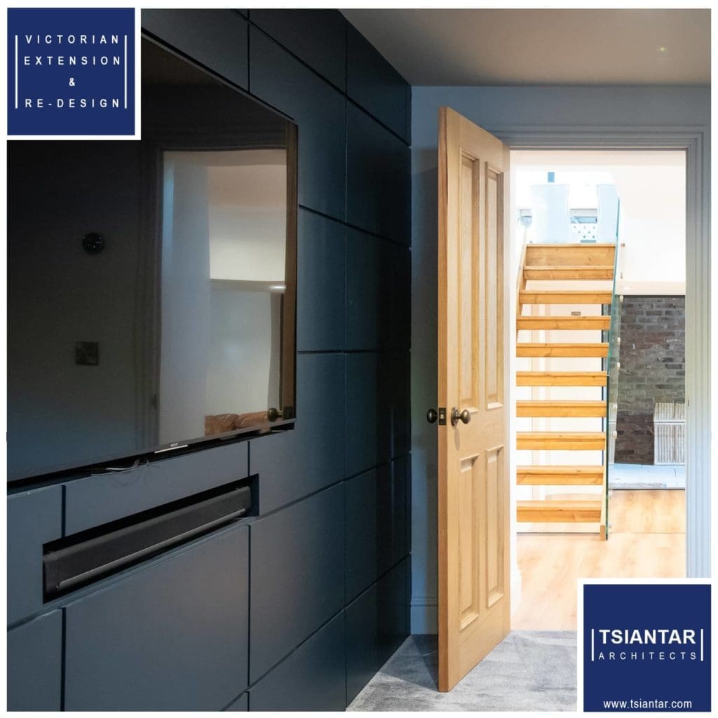 A room with a tv and a wooden staircase.