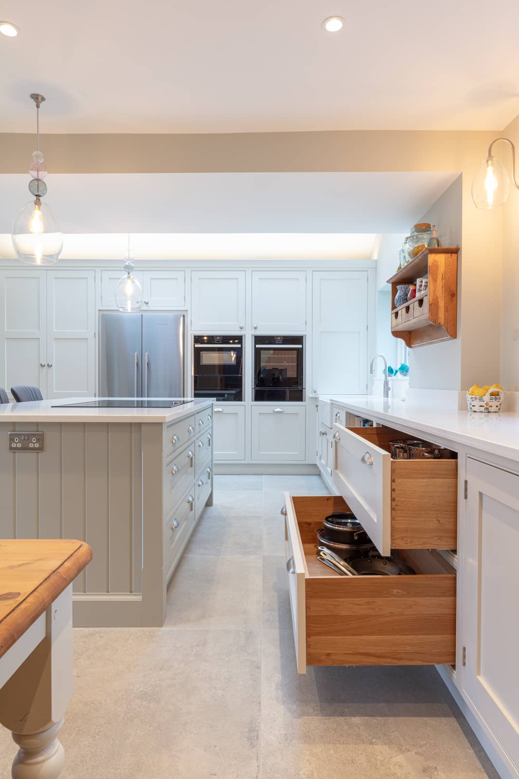 A white kitchen with wooden cabinets and drawers.