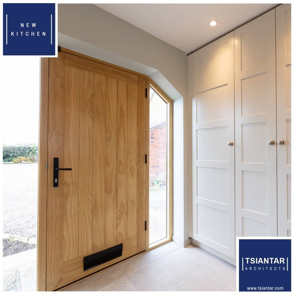A farmhouse transformation with a wooden door in a hallway and white cabinets.