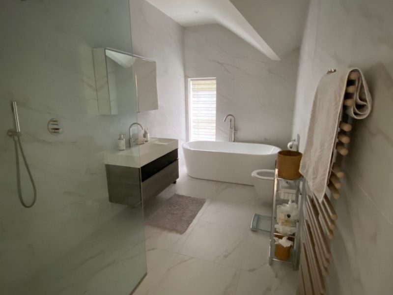 A white bathroom with a bathtub and shower.