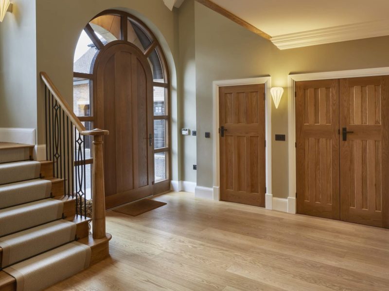 a large foyer with a wooden door and stairs.