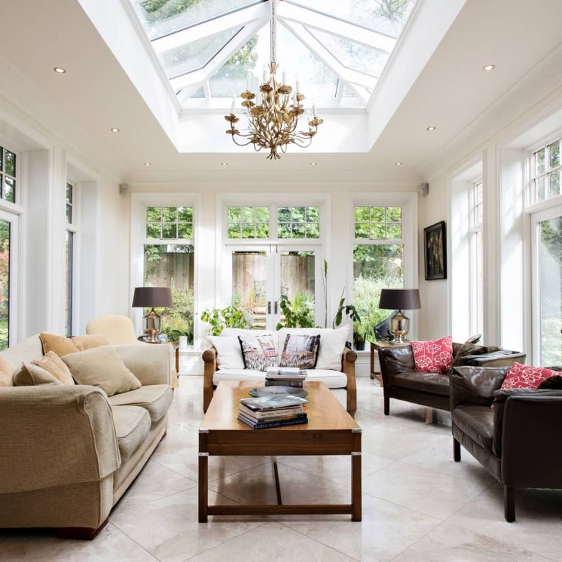 A spacious living room with a grand skylight undergoing renovation.